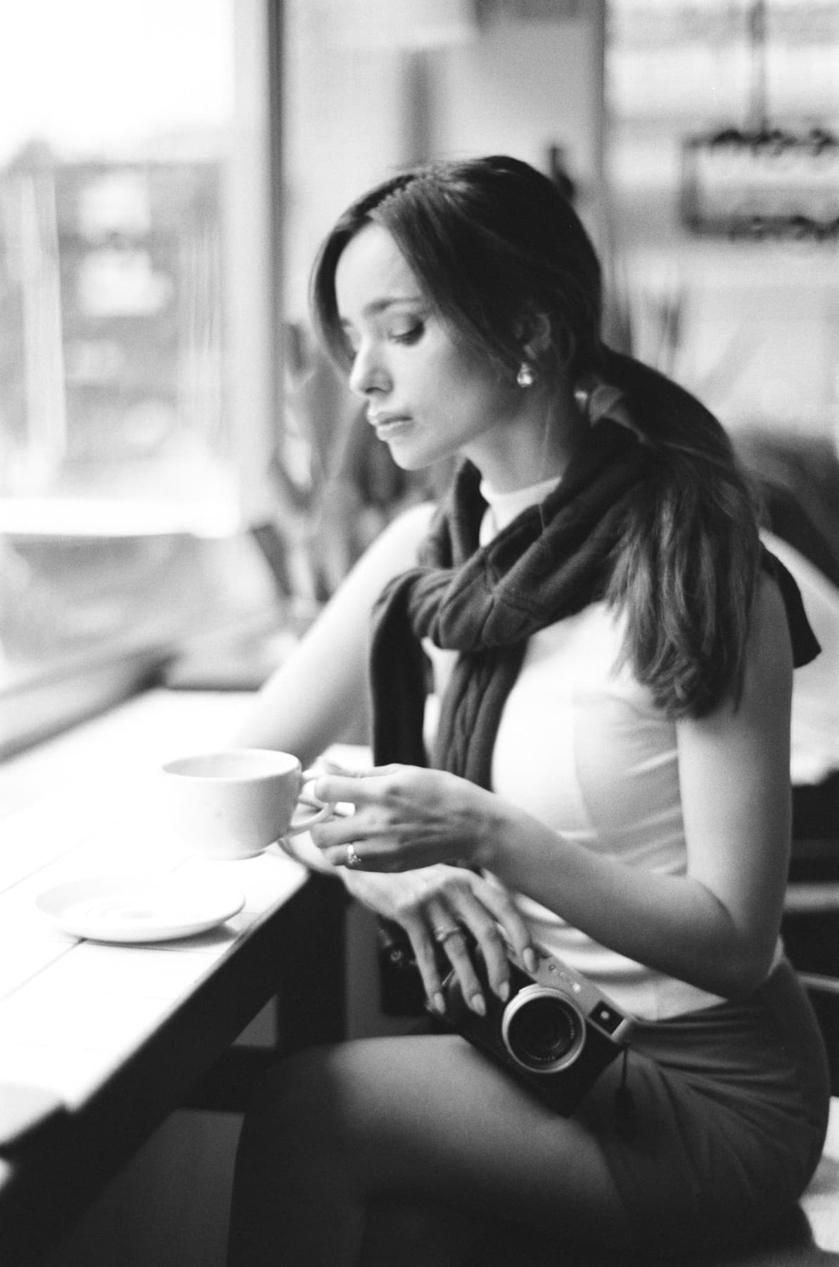 A woman seated by a window, in thought.