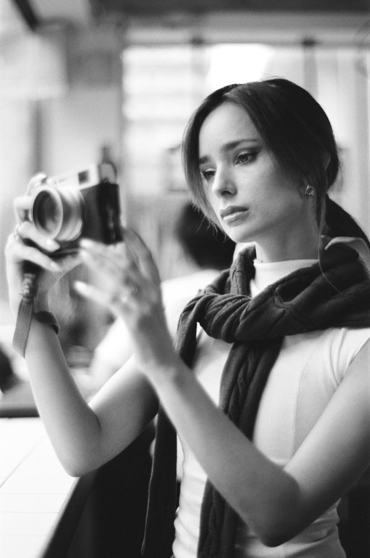A woman holding a camera to her eye.