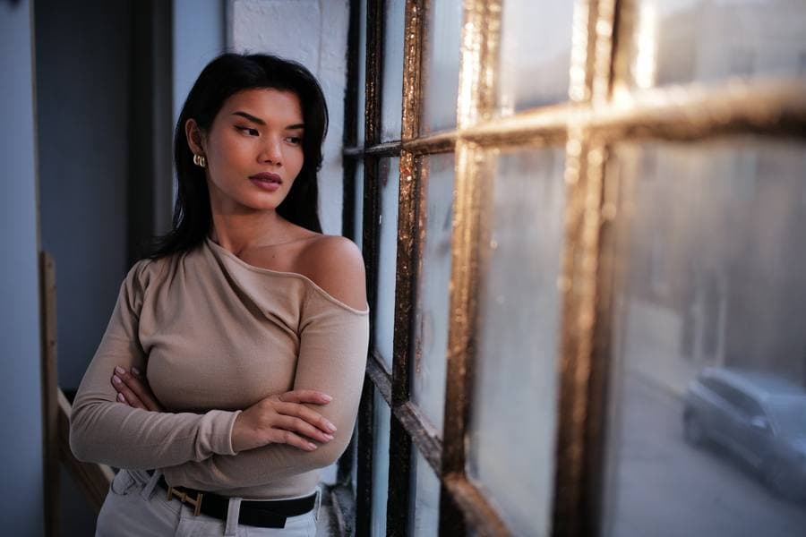 Portrait in window light, arms crossed.